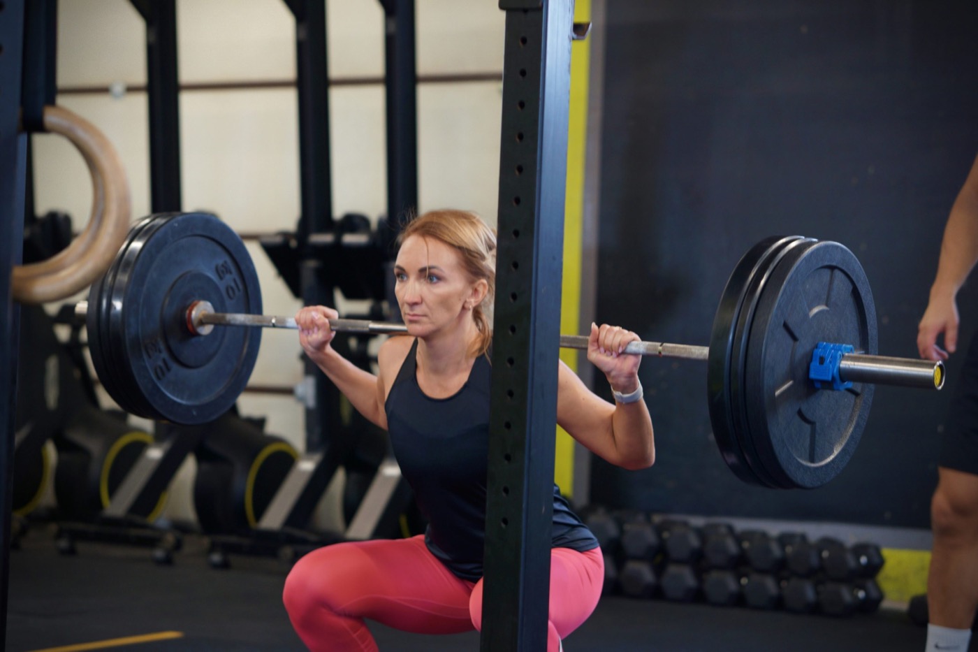 Athlete squatting with coach support at CrossFit Urban Tribe